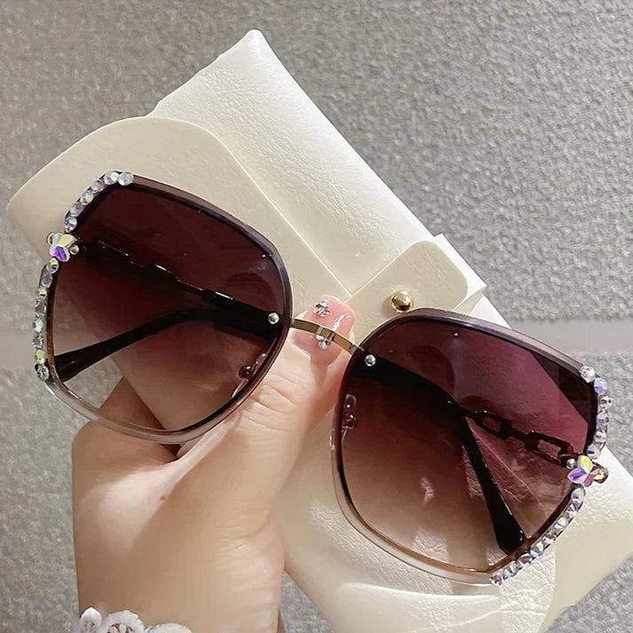 Détail des cristaux scintillants sur les lunettes de soleil femme sans monture, verres teintés.