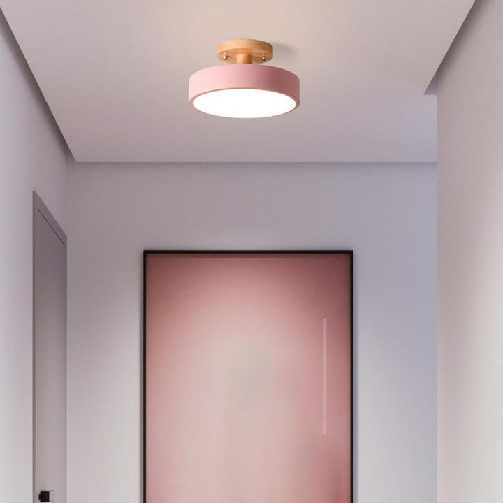 Plafonnier scandinave en bois naturel, accents pastel. Ambiance chaleureuse.