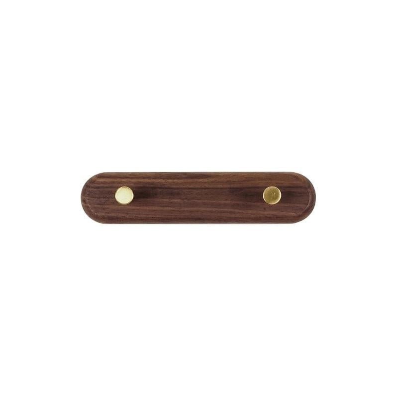 Rangement d'entrée compact : porte-manteau mural en bois clair et laiton brillant pour les manteaux.