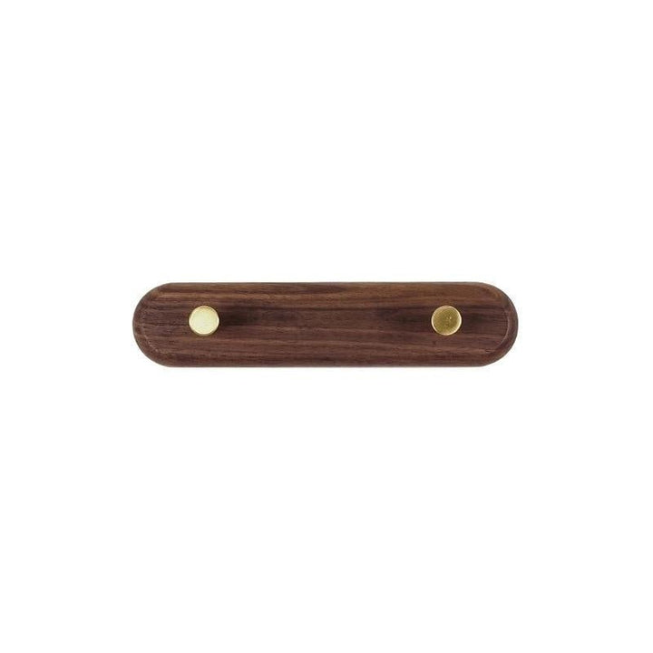 Rangement d'entrée compact : porte-manteau mural en bois clair et laiton brillant pour les manteaux.