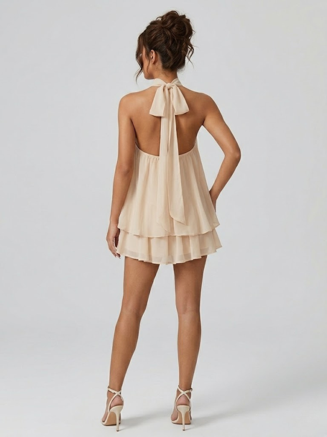 Mini robe estivale chic avec dos nu élégant, col halter et volants féminins. Tendance mode femme.