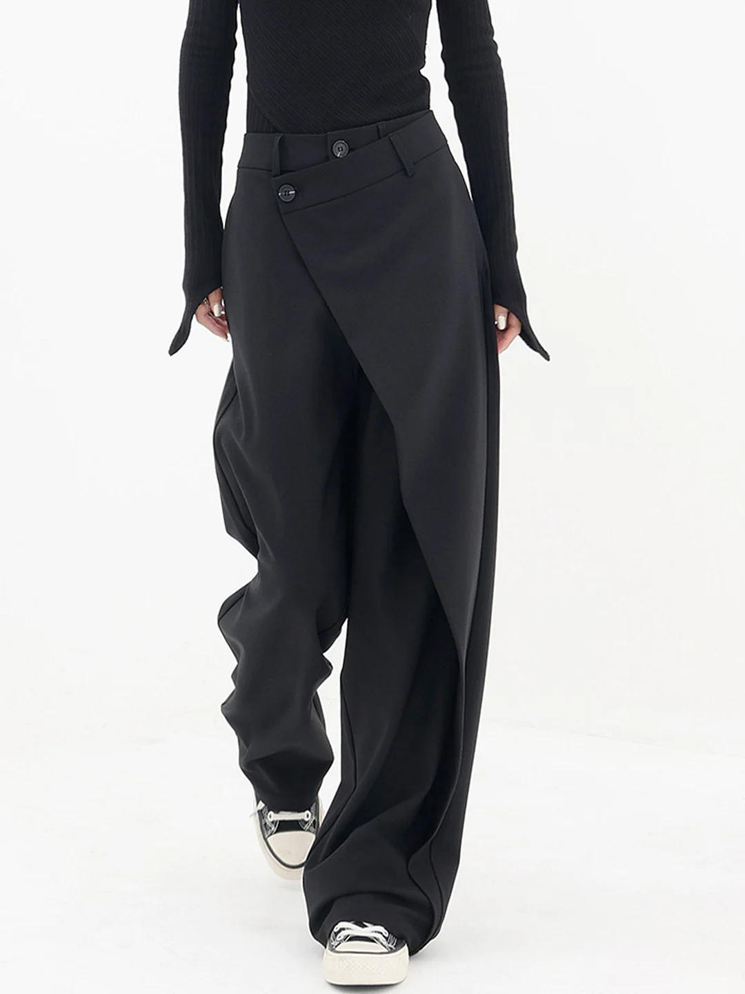 Femme portant un pantalon baggy asymétrique noir, taille haute, pour un look décontracté-chic.