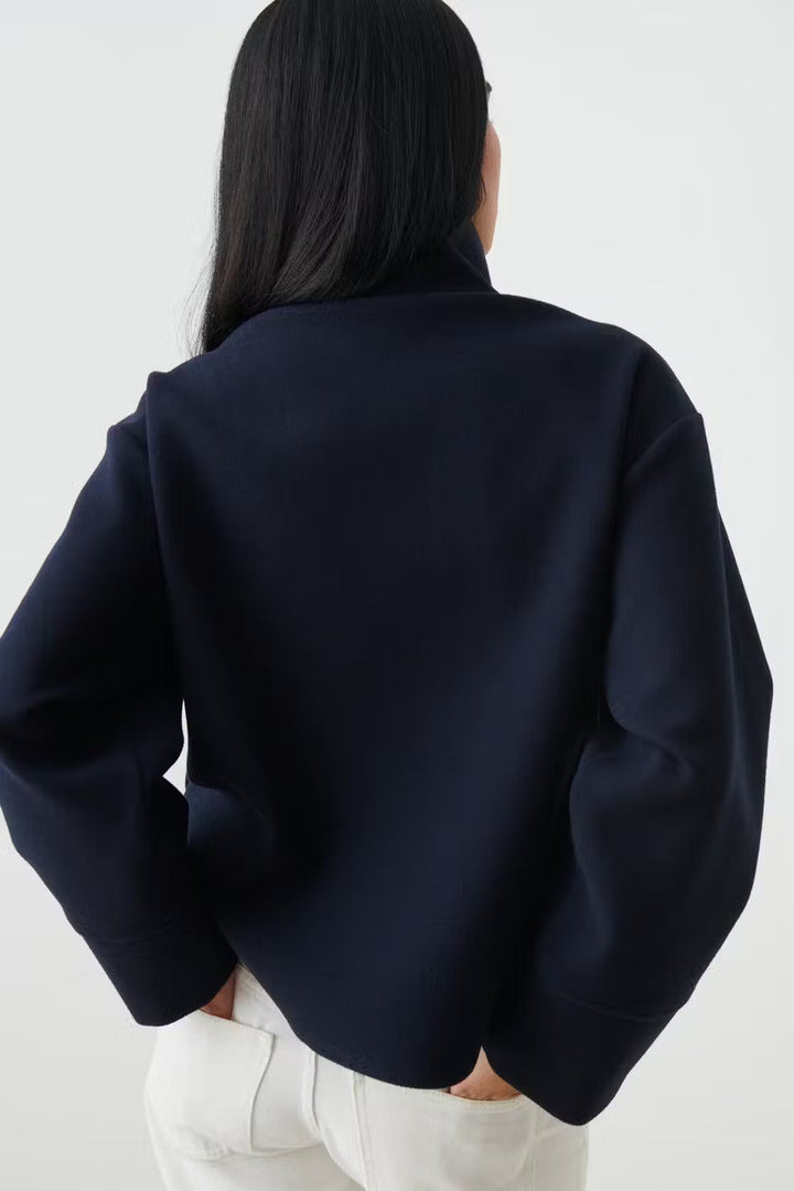 Veste chic femme bleu foncé, col montant élégant. Idéale pour une tenue de bureau moderne.