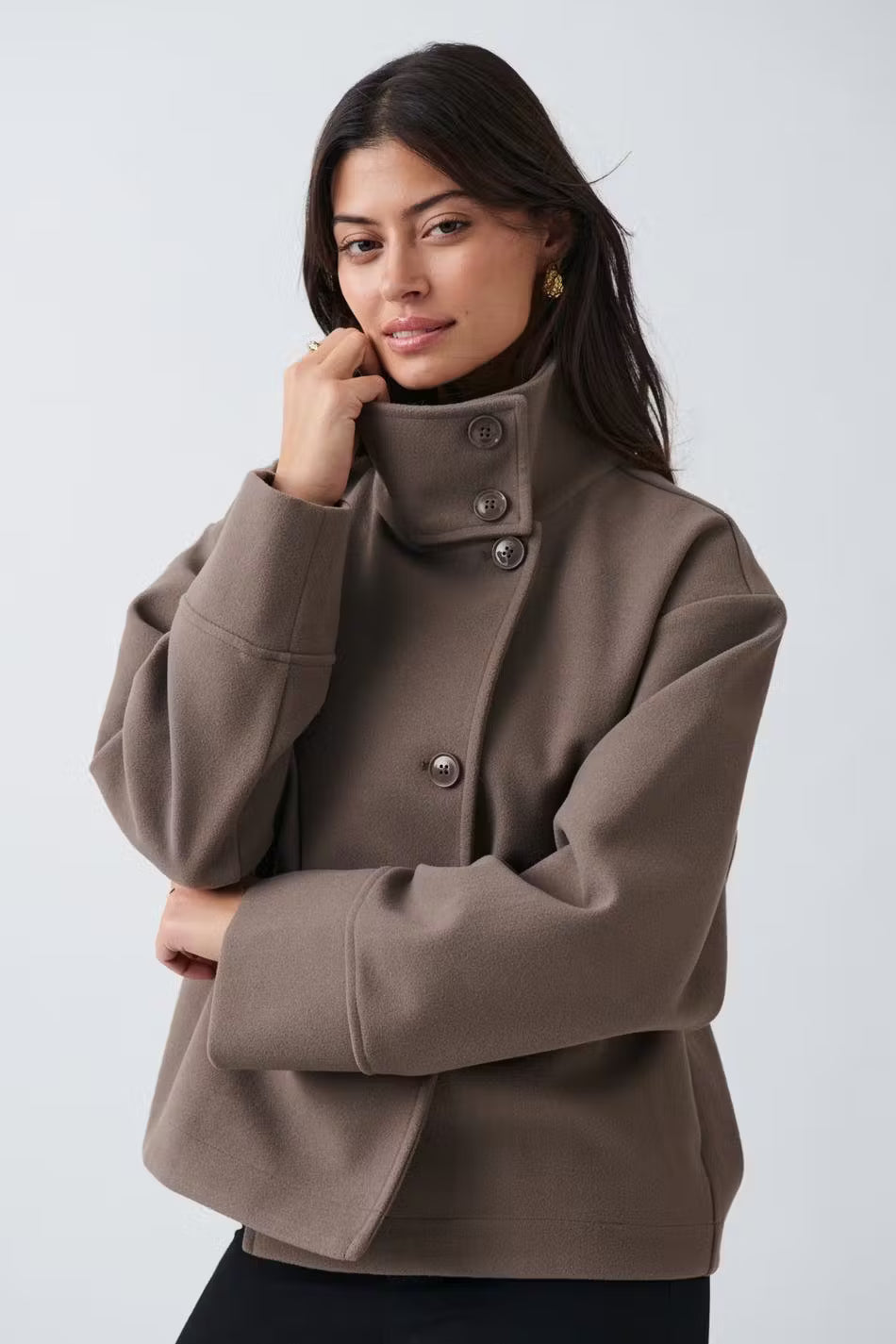 Veste femme moderne à col montant, coupe courte. Tenue de bureau sophistiquée et minimale.