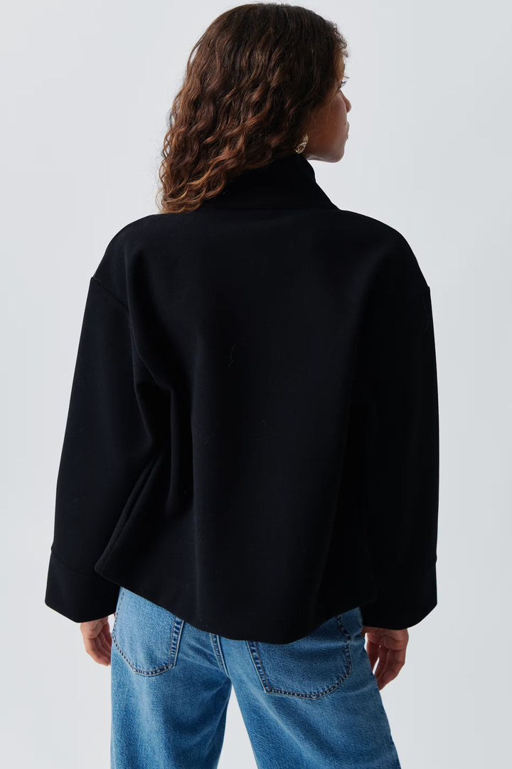 Veste élégante femme, minimaliste. Col montant, parfaite pour un style urbain ou tenue de bureau.