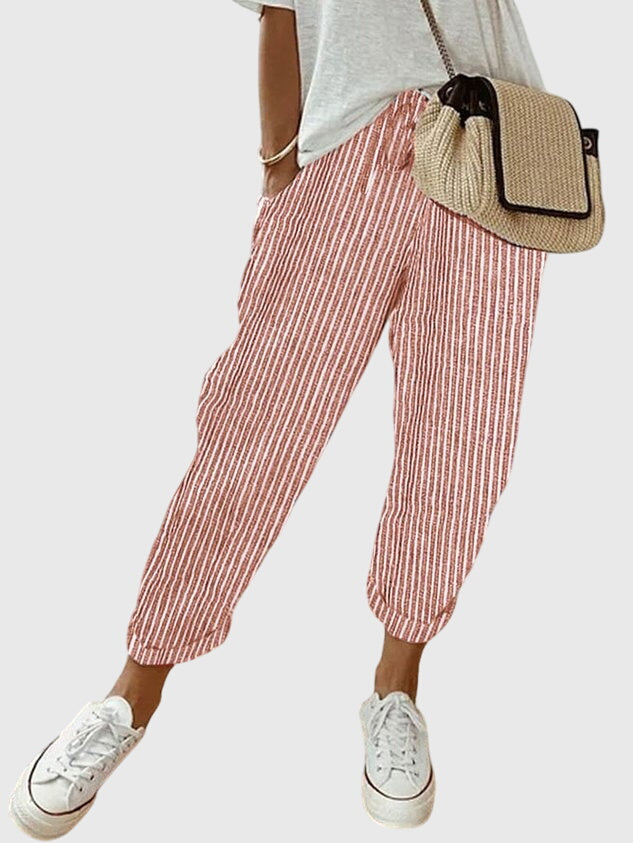 Femme portant un pantalon taille haute jambe droite, style raffiné, pour une tenue printanière chic.