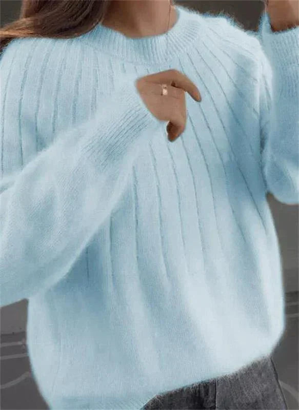 Pull femme en tricot doux posé à plat. Un vêtement chaud, confortable et moderne pour l'automne et l'hiver.