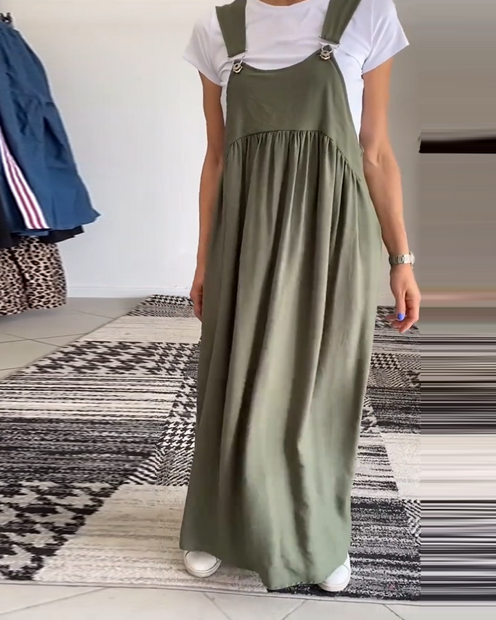 Femme portant robe salopette noire fluide, style élégant et décontracté, mode printemps-été.