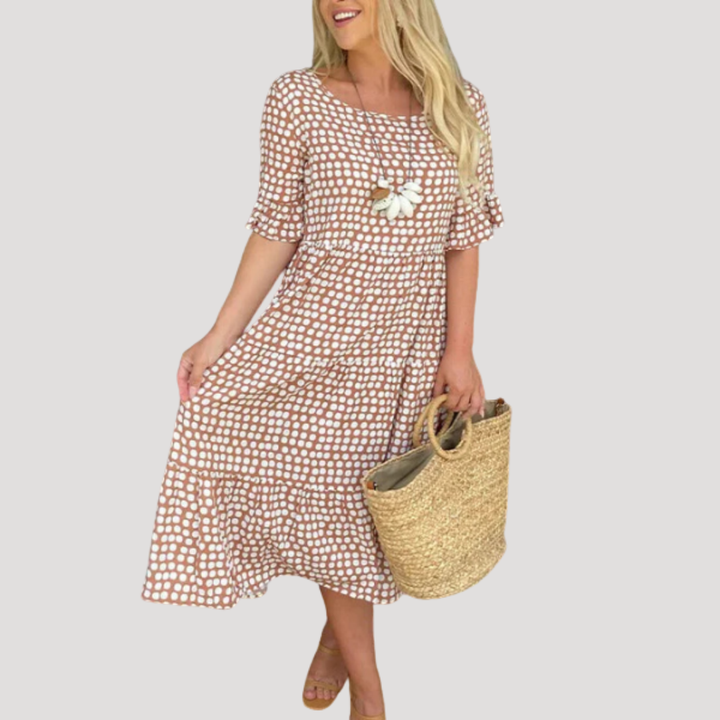 Silhouette d'une femme en robe midi fluide à pois, parfaite pour le printemps/été, alliant confort et élégance.