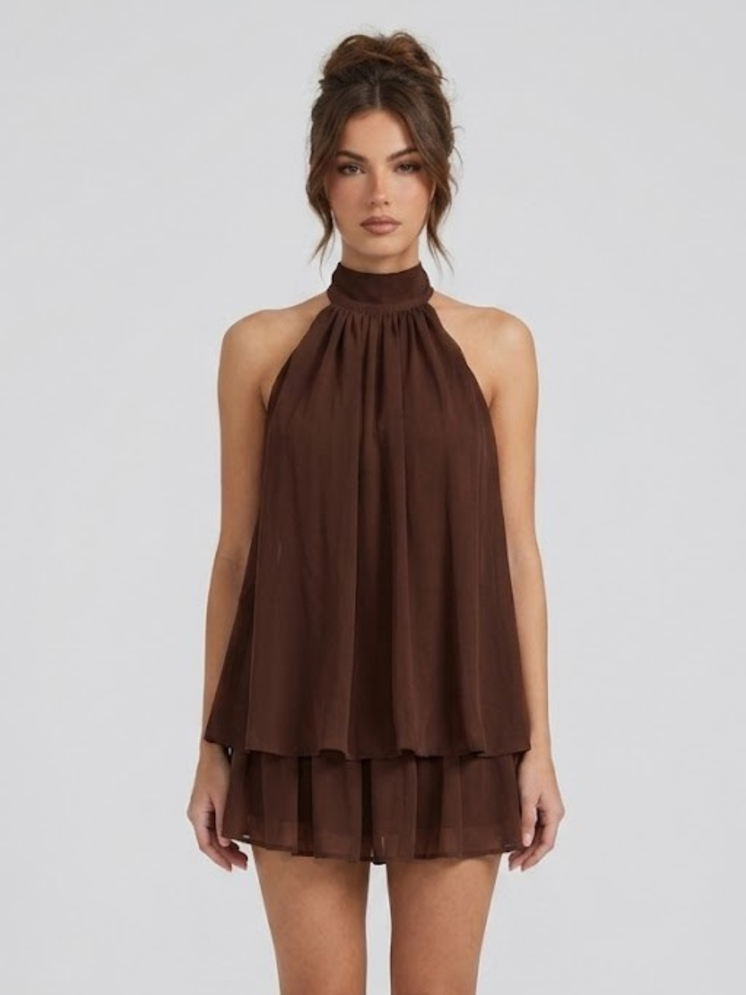 Robe courte féminine, dos nu, col halter, style volanté tendance pour l'été. Mode estivale moderne.