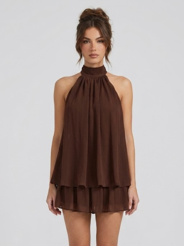 Robe courte féminine, dos nu, col halter, style volanté tendance pour l'été. Mode estivale moderne.