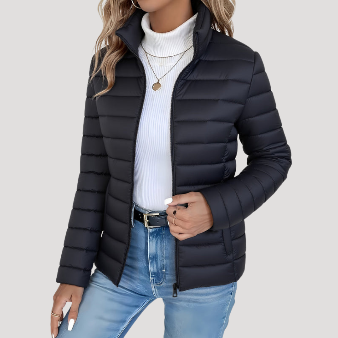 Femme portant une élégante veste matelassée zippée à col montant. Idéale pour l'automne-hiver, alliant style et chaleur.