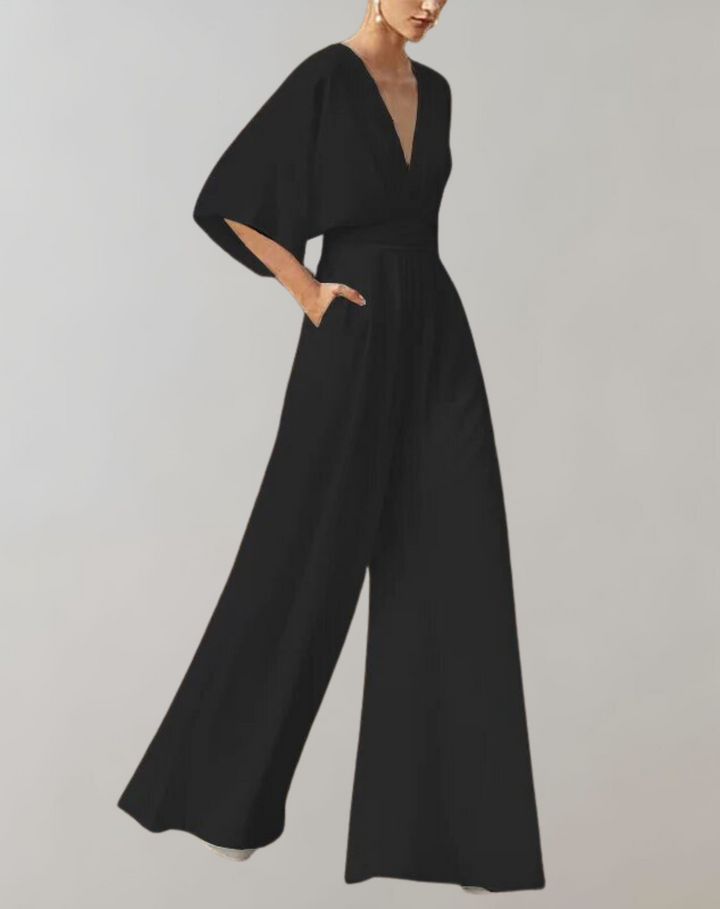 Combinaison noire femme élégante avec décolleté plongeant et pantalon large pour une silhouette sophistiquée.