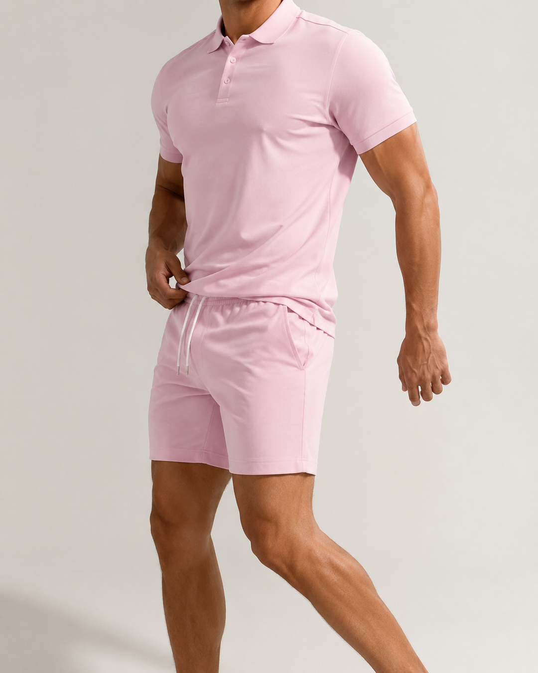 Homme portant un ensemble polo-short chic et confortable, prêt pour l'été et les loisirs décontractés.