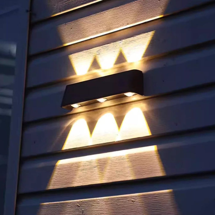 Design moderne pour cette applique murale solaire LED, offrant un éclairage blanc chaud doux pour l'extérieur.