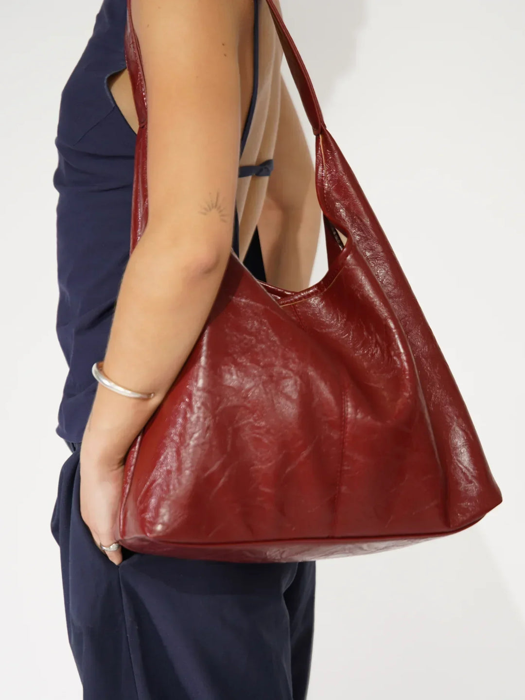 Femme portant un sac bandoulière en cuir vegan élégant, accessoire mode indispensable.