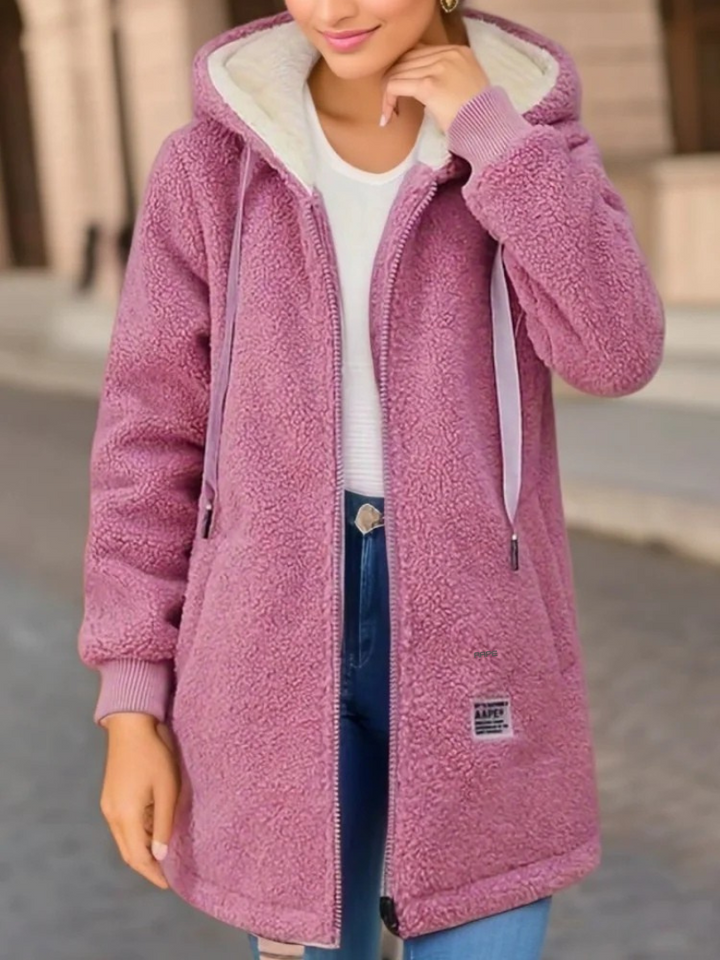 Gros plan du tissu moelleux du sweat à capuche femme Perla. Chaleur douillette et style hivernal pour elle.