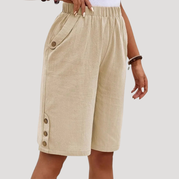Bermuda femme chic avec détails boutons et taille élastique, pour une silhouette féminine et confortable en été.