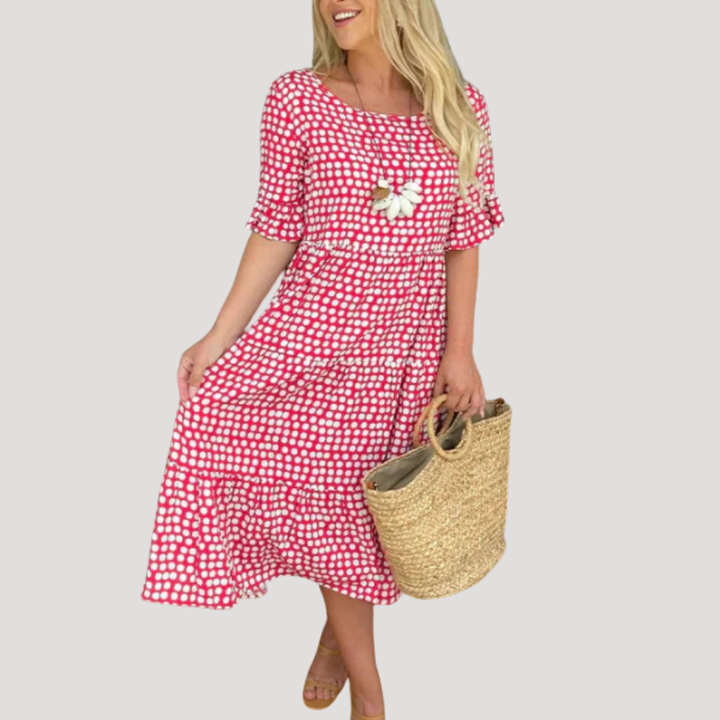Femme portant une robe midi fluide noire à pois blancs, confortable et chic pour le quotidien au printemps.
