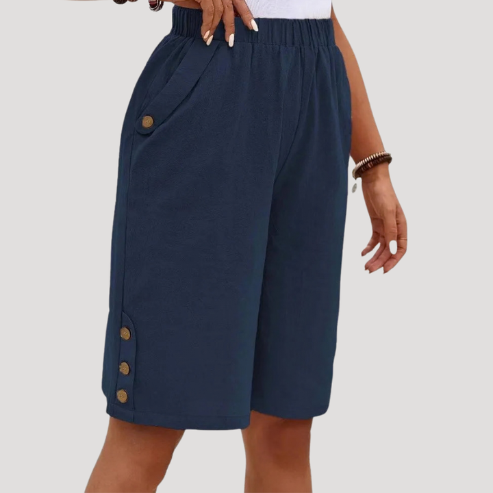 Bermuda femme élégant et décontracté. Sa taille élastique et ses boutons offrent chic et confort pour la saison estivale.