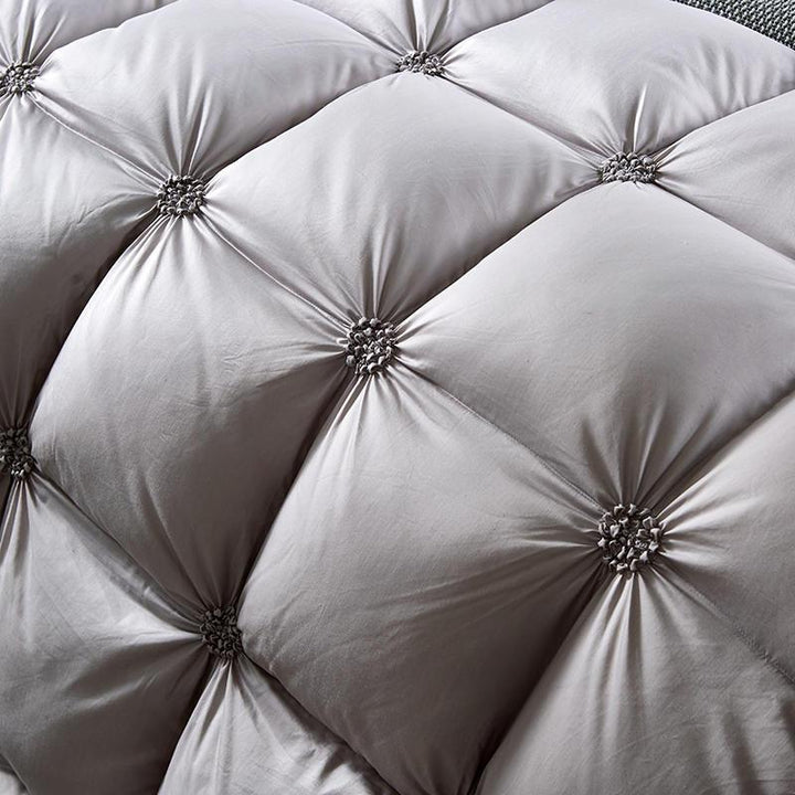 Motif matelassé élégant d'une couette en plumage d'oie, gage de luxe et de douceur pour la literie.