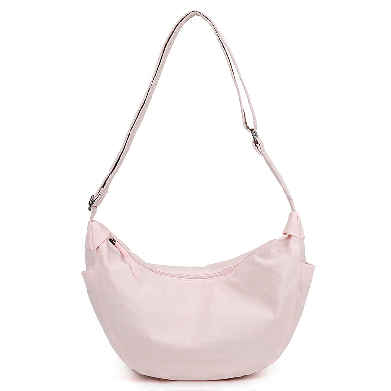 Gros plan sur le sac à bandoulière femme demi-lune. Détails élégants et bandoulière ajustable visible.
