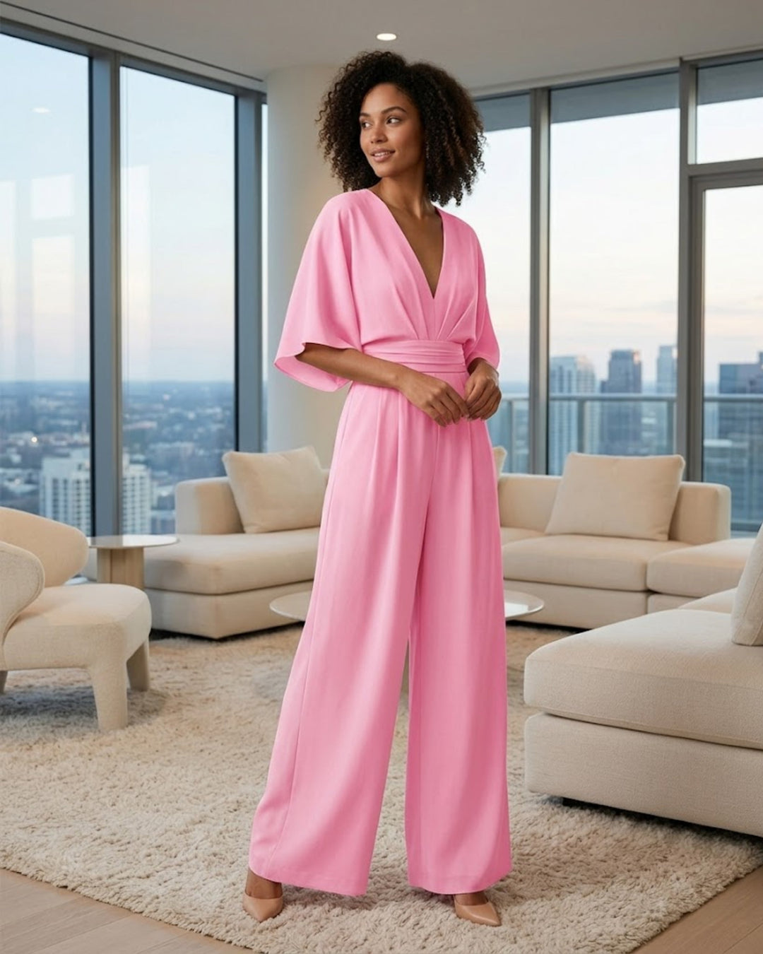 Combinaison femme élégante noire, décolleté plongeant et jambes larges. Idéale pour soirée chic et moderne.
