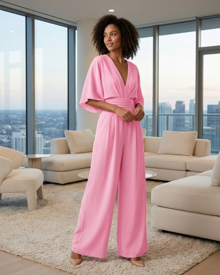 Combinaison femme élégante noire, décolleté plongeant et jambes larges. Idéale pour soirée chic et moderne.