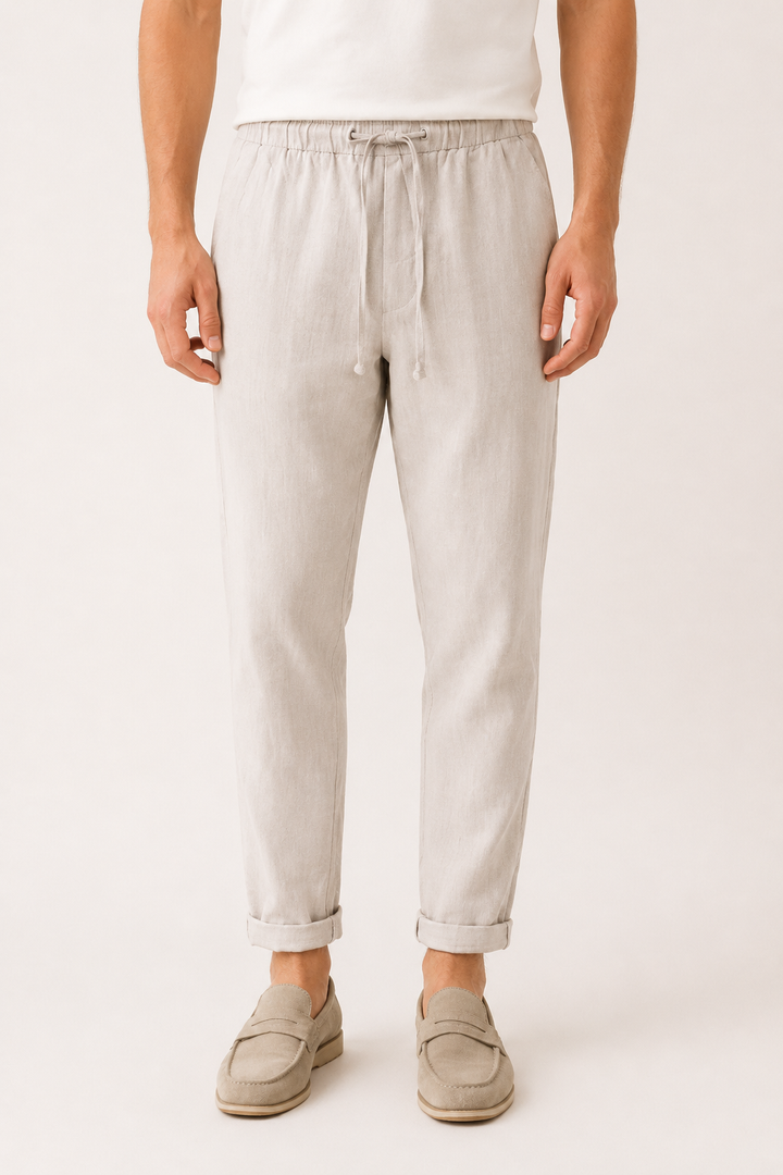 Homme portant un pantalon décontracté léger. Taille élastique, coupe droite. Confortable pour l'été et le voyage.