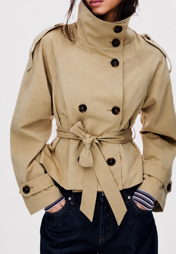 Trench-coat court femme kaki élégant avec col montant, coupe ceinturée. Idéal mi-saison chic.