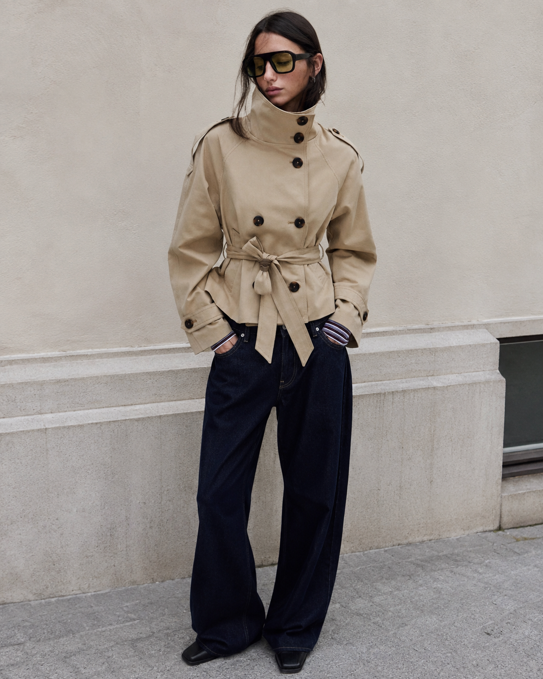 Trench-coat femme kaki élégant, coupe courte, col montant structuré. Ceinture ajustée pour une silhouette chic.