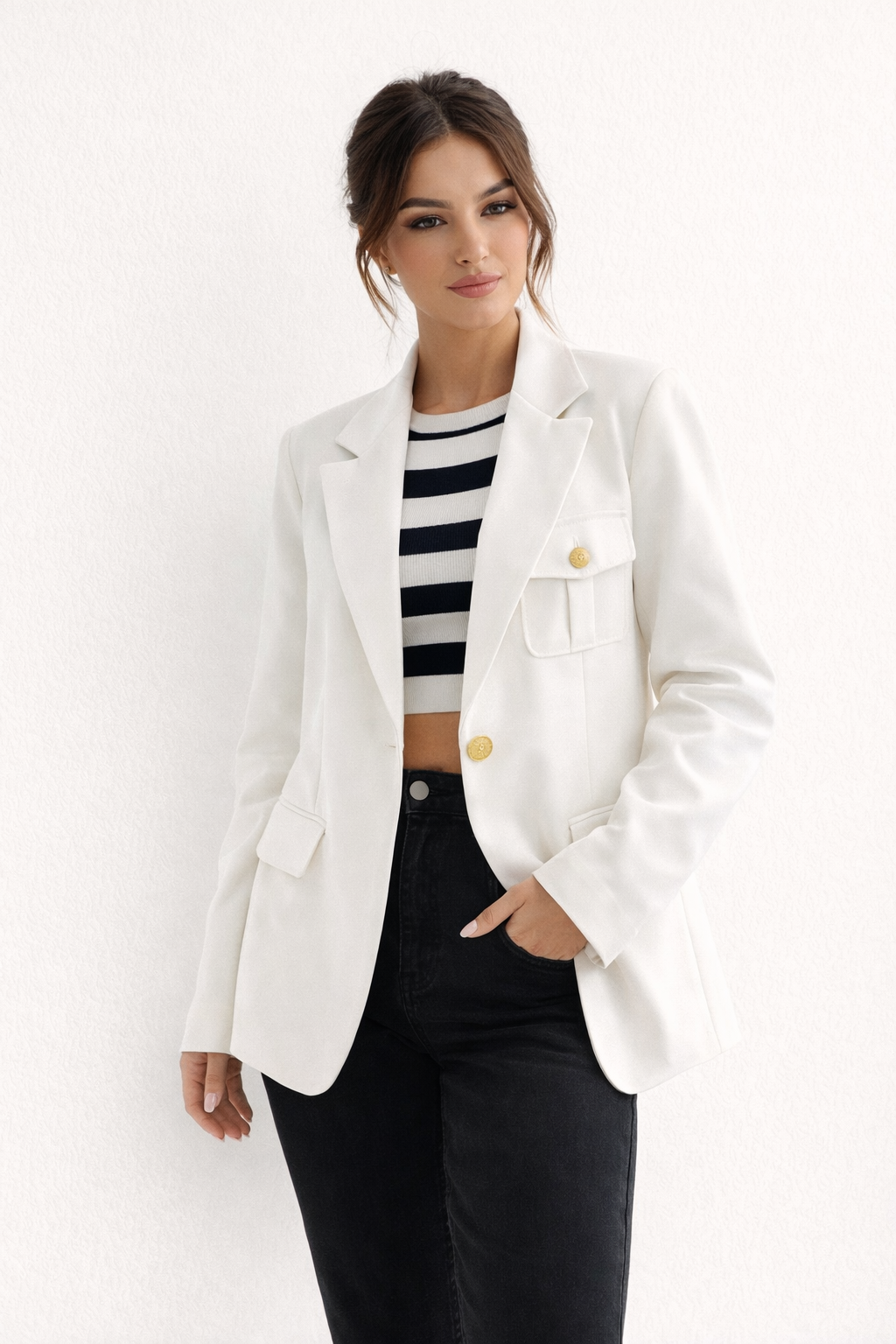 Femme portant un blazer ajusté élégant, look professionnel chic idéal pour le bureau ou une cérémonie.