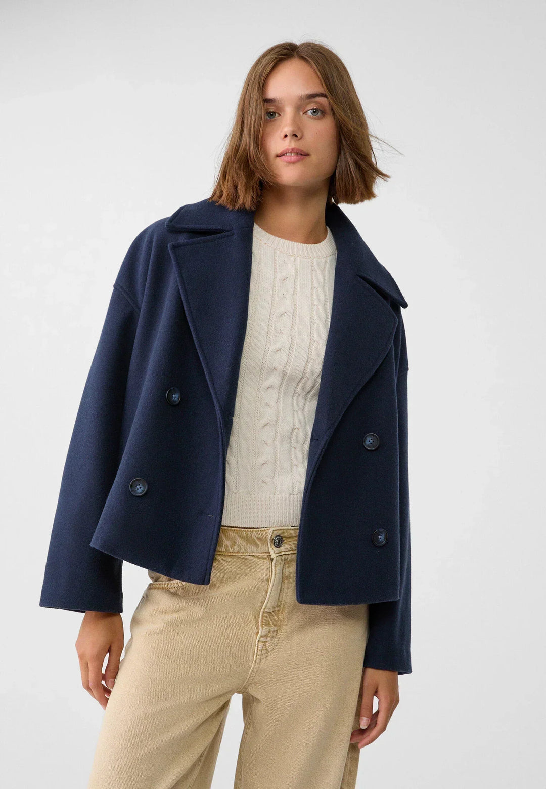 Peacoat élégant femme, coupe moderne, double boutonnage, pour un look mode féminine printanier.