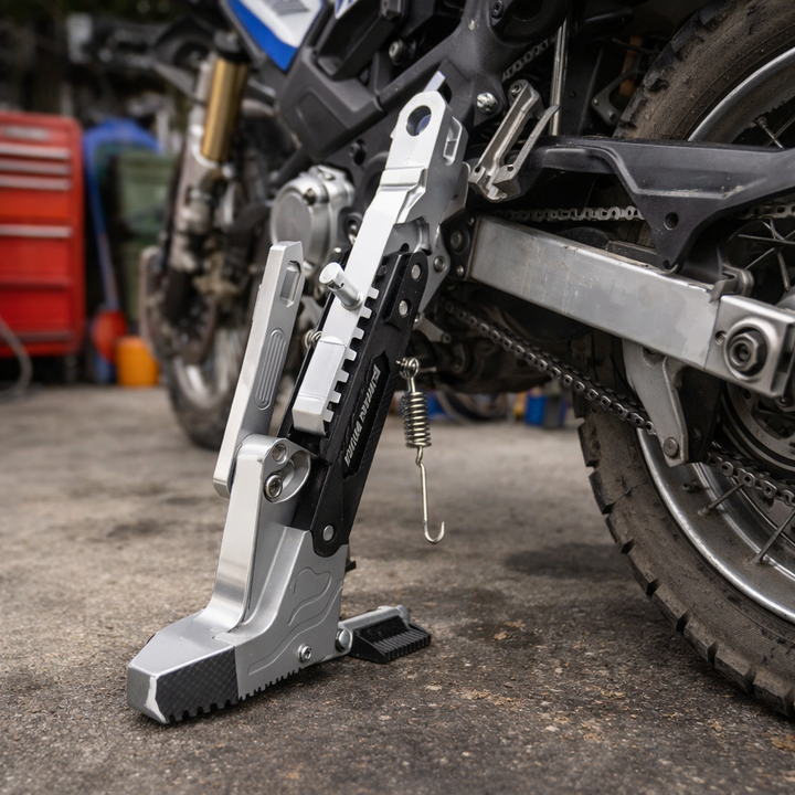Support de béquille latérale moto en métal argenté robuste pour un stationnement stable et fiable.