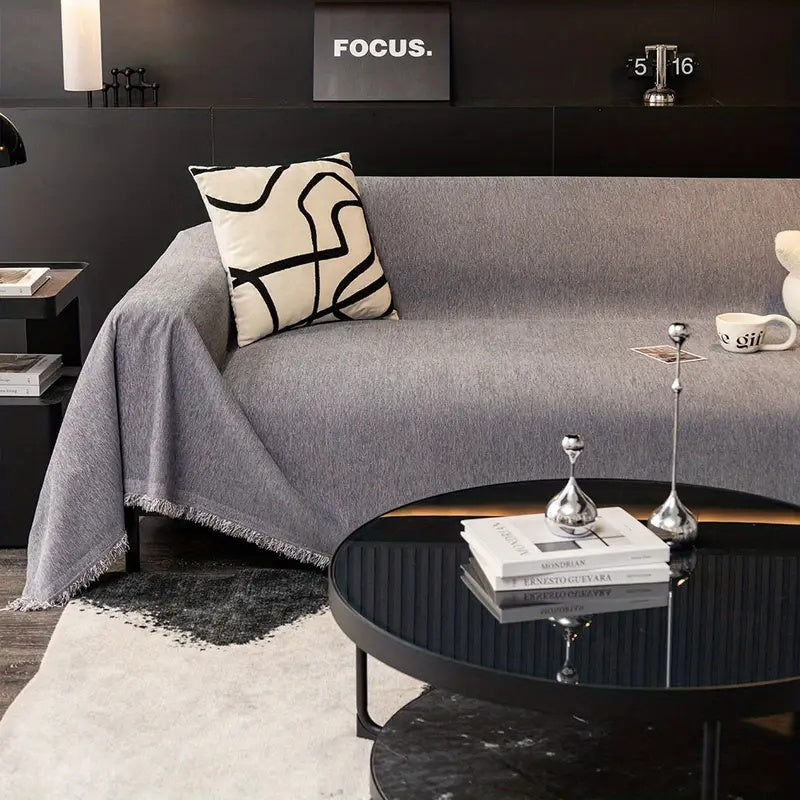 Housse de canapé texturée avec pampilles, ameublement tendance pour salon moderne.
