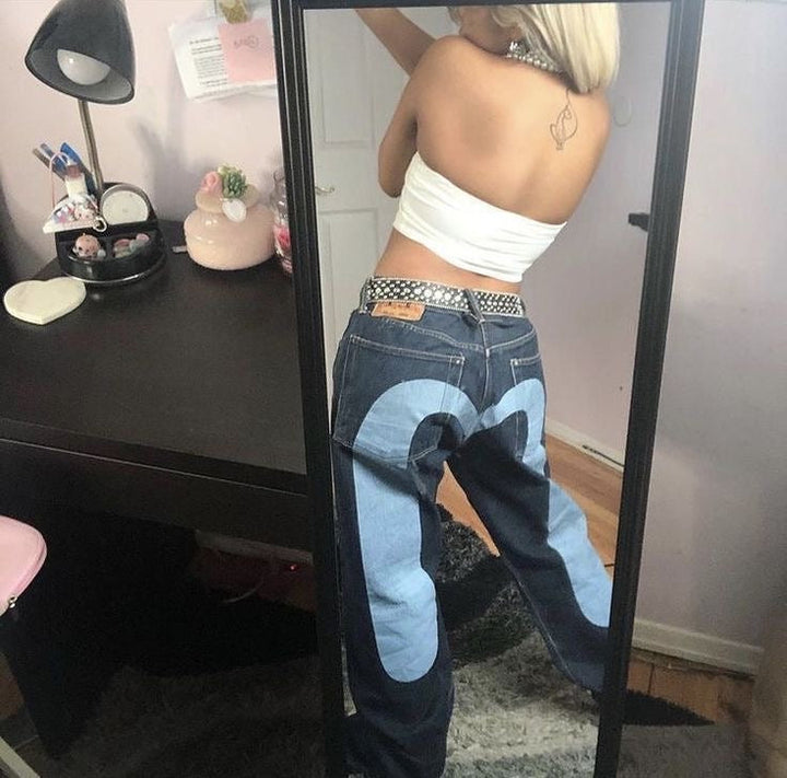 Femme portant un jean rétro streetwear ample et confortable, taille mi-haute. Look décontracté vintage très tendance.