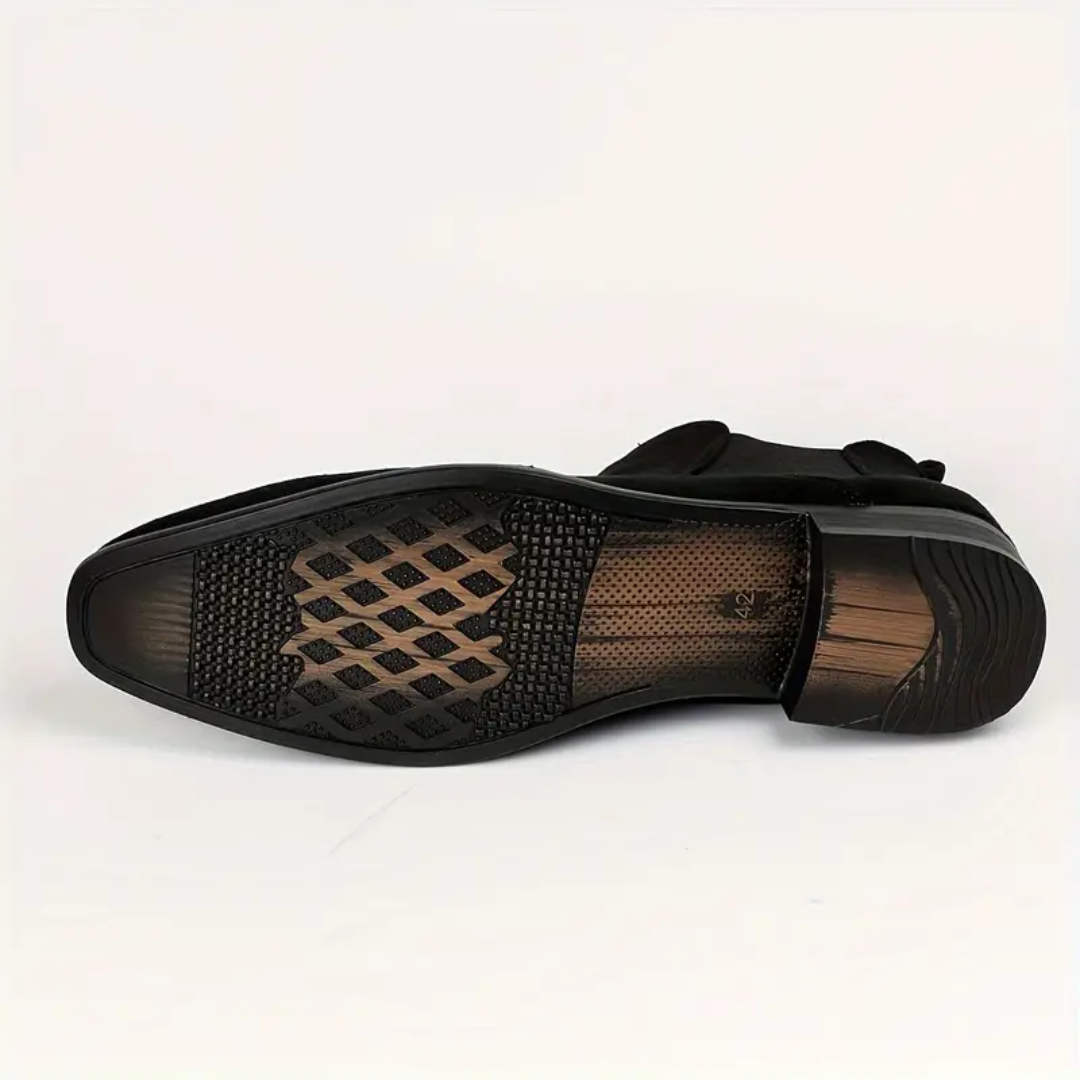 Détail d'une bottine Chelsea homme noire, mettant en valeur le cuir et les soufflets élastiques, pour un look chic.