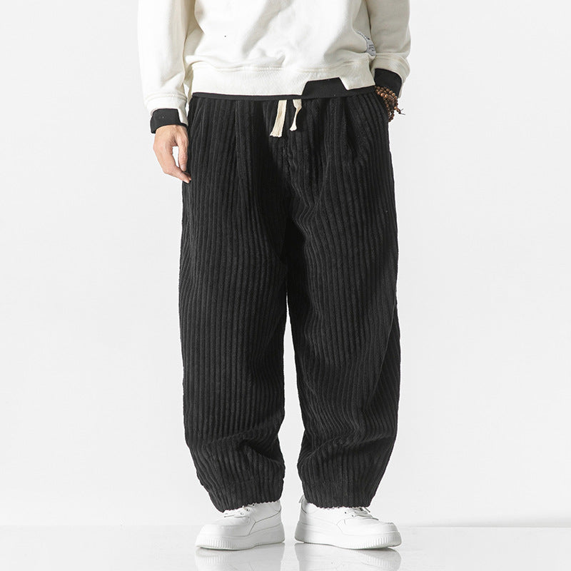 Homme portant un pantalon urbain chic noir, look moderne et confortable, idéal pour la mode masculine.