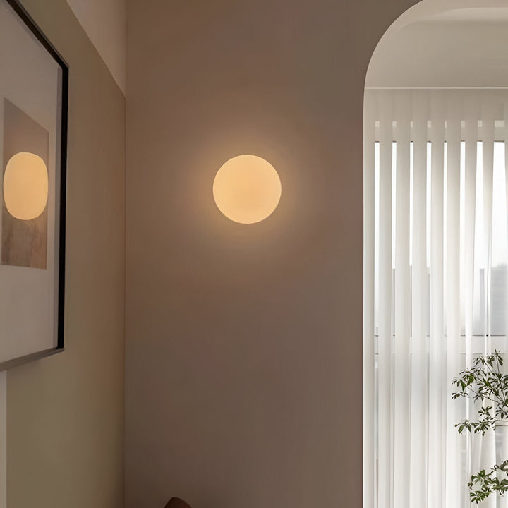 Éclairage mural moderne, applique ronde diffusant une lumière chaude et accueillante.