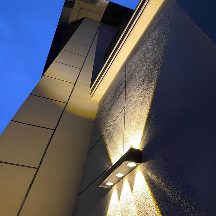 Applique solaire LED blanc chaud, design moderne sublimant un mur de jardin, une terrasse ou une façade.