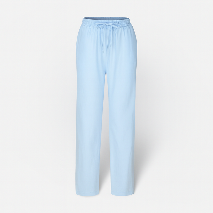 Femme portant un pantalon en coton et lin fluide et décontracté, marchant avec style et confort.