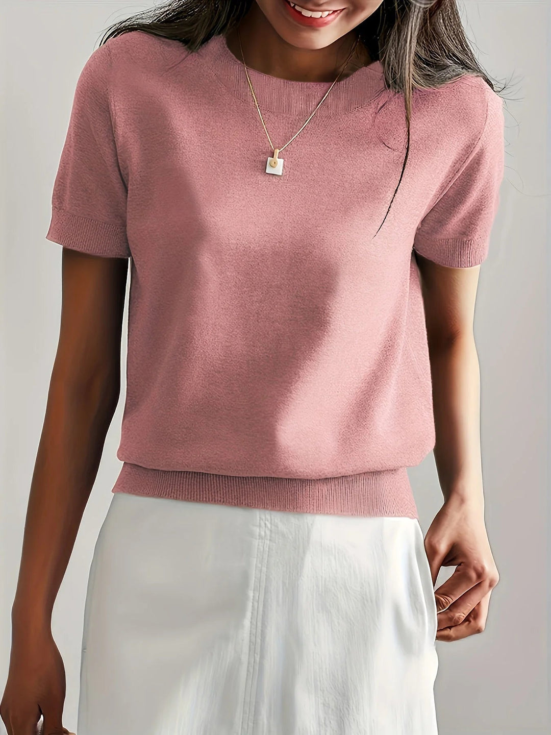 Léger pull à manches courtes pour femme, idéal pour un look décontracté et chic au printemps.