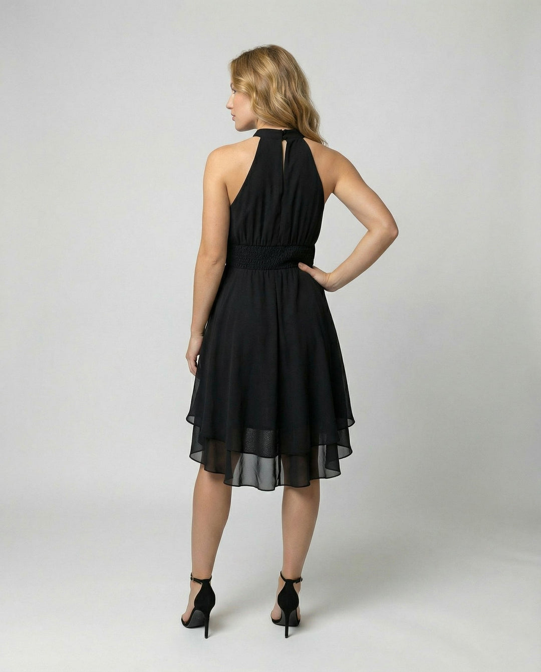 Robe de soirée élégante sans manches, mini plissée, pour femme moderne et stylée.