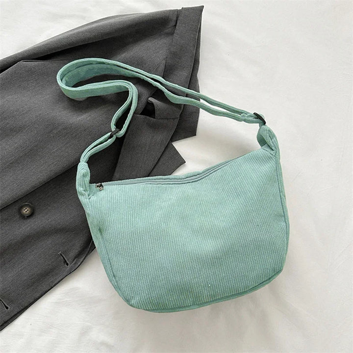 Gros plan : texture riche du sac banane velours femme, un accessoire mode hiver chic et tendance.