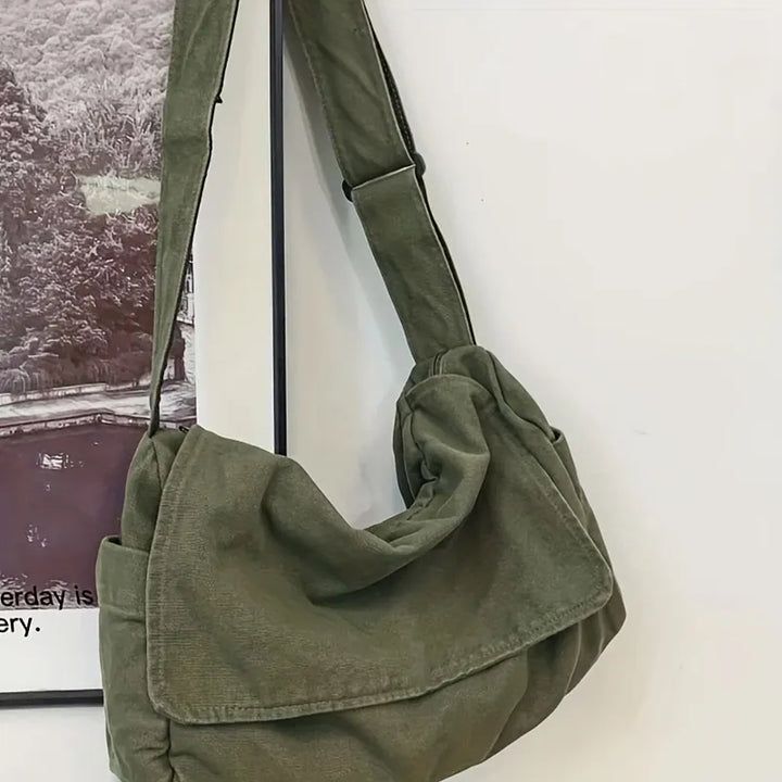 Sac besace unisexe en toile recyclée. Design moderne, disponible en noir, vert ou beige. Durable et pratique.