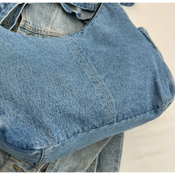 Détail du sac en jean femme: fermetures éclair robustes et finitions soignées du denim.