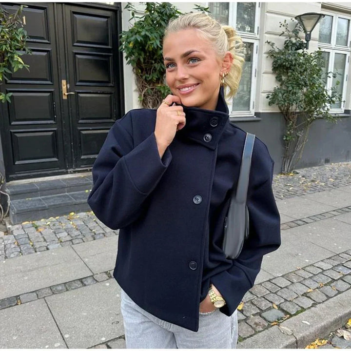 Veste courte femme noire, boutonnage asymétrique unique. Minimaliste et élégante pour la ville.