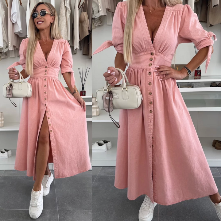 Femme portant une robe midi boutonnée en jean, col V, look féminin et moderne.
