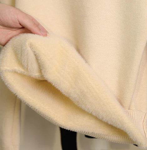 Femme relaxant avec un pull col roulé polaire doux et chaud, parfait pour les moments de détente hivernaux.