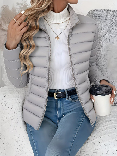 Veste doudoune femme avec fermeture éclair, matelassée, légère, offrant chaleur et protection en extérieur.